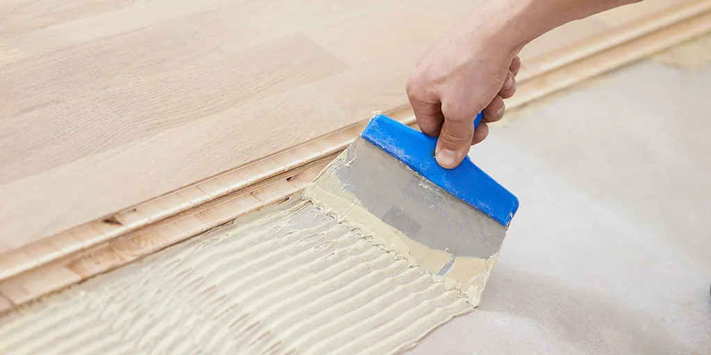 ¿Qué tan importante es el tipo de adhesivo utilizado para instalar un piso de madera de ingeniería?