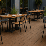 Deck sintético Tekno-Step instalado en una terraza exterior con mesas y sillas, mostrando su acabado natural y resistente.