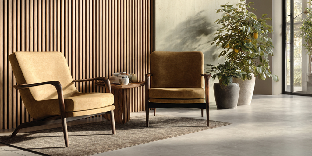 Sala moderna con muro de lambrín de listones verticales en acabado madera, sillones en tonos café y planta decorativa con luz natural.