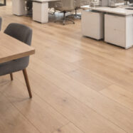 Oficina moderna con piso laminado SPC de madera clara y mobiliario contemporáneo